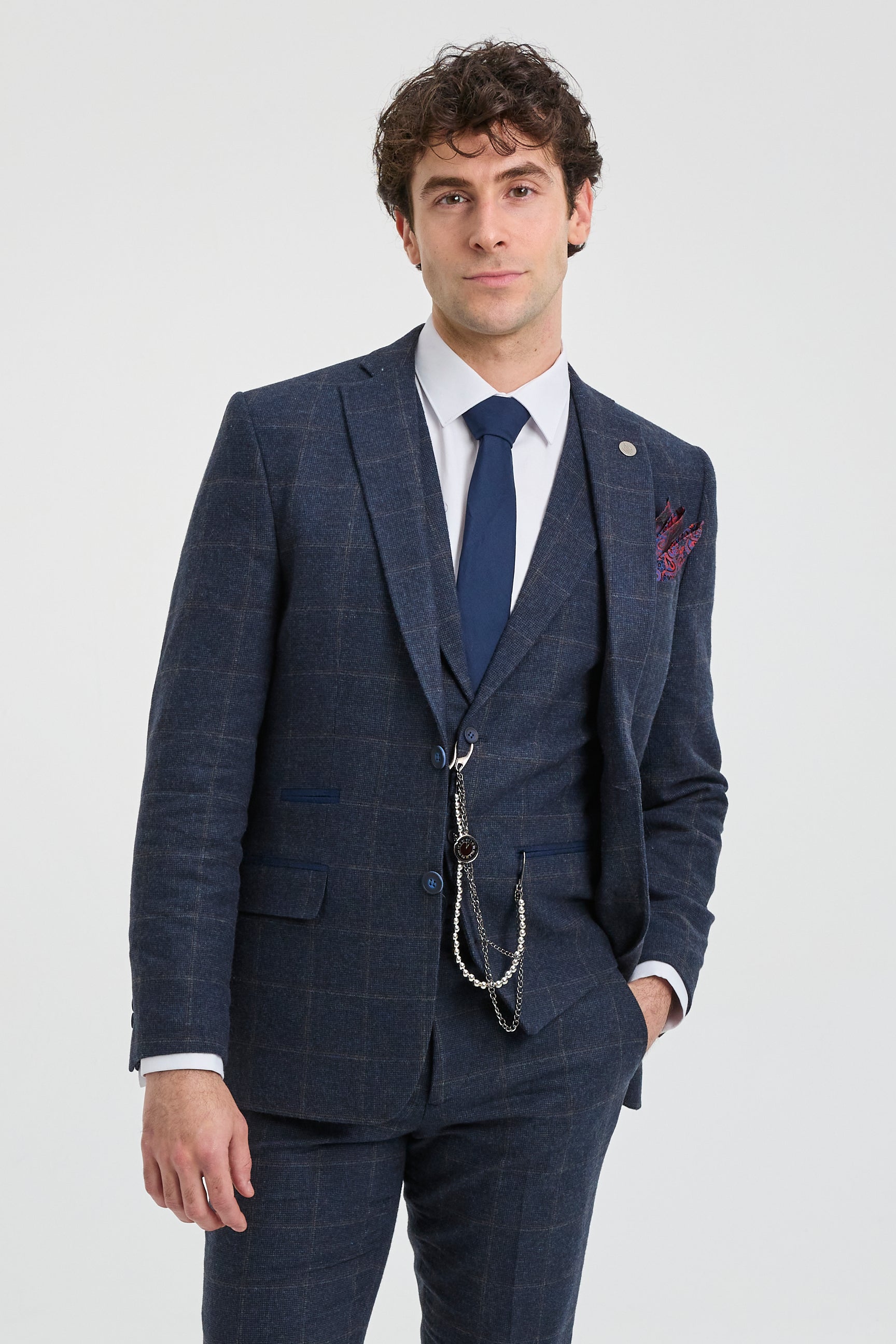 Άνδρας που φοράει μπλε καρό κοστούμι με λευκό πουκάμισο και μπλε γραβάτα σε ανοιχτό γκρι φόντο